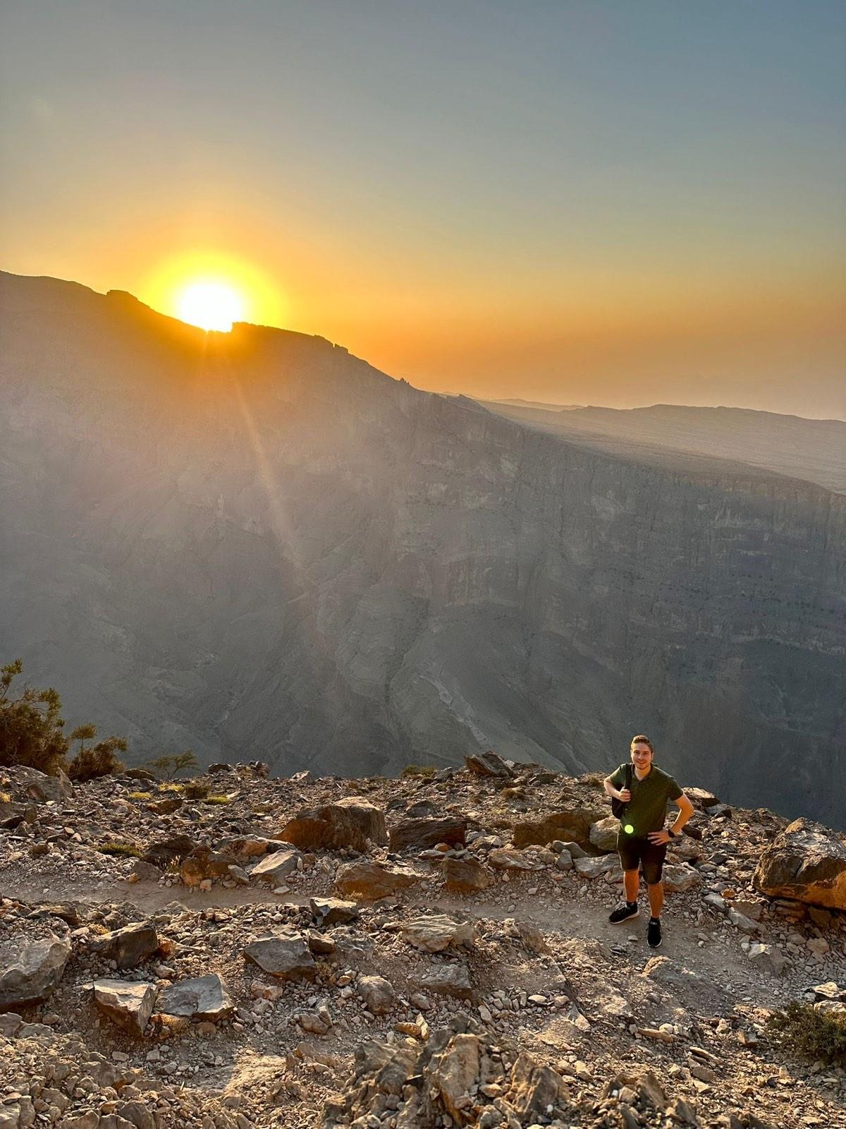 Hiker on the canyon rim in low sun