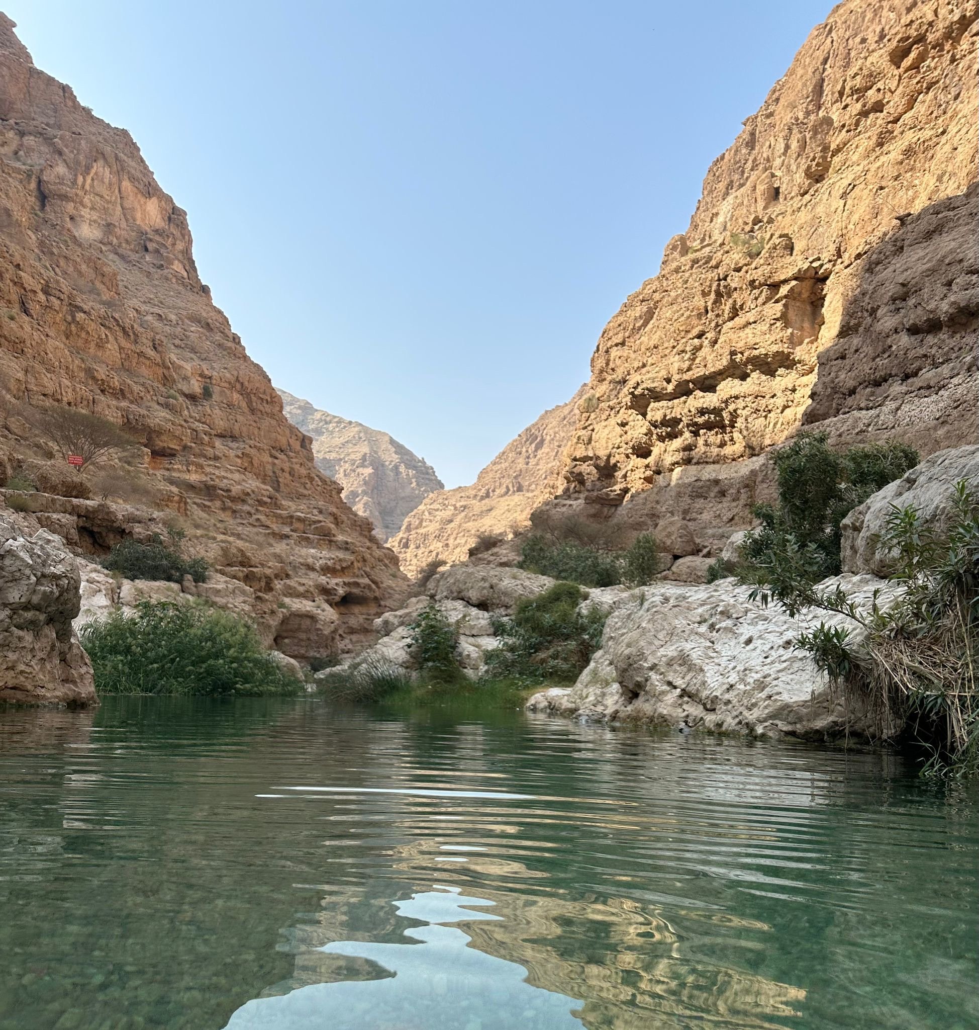 Turquoise water between the steep rock walls of the wadi